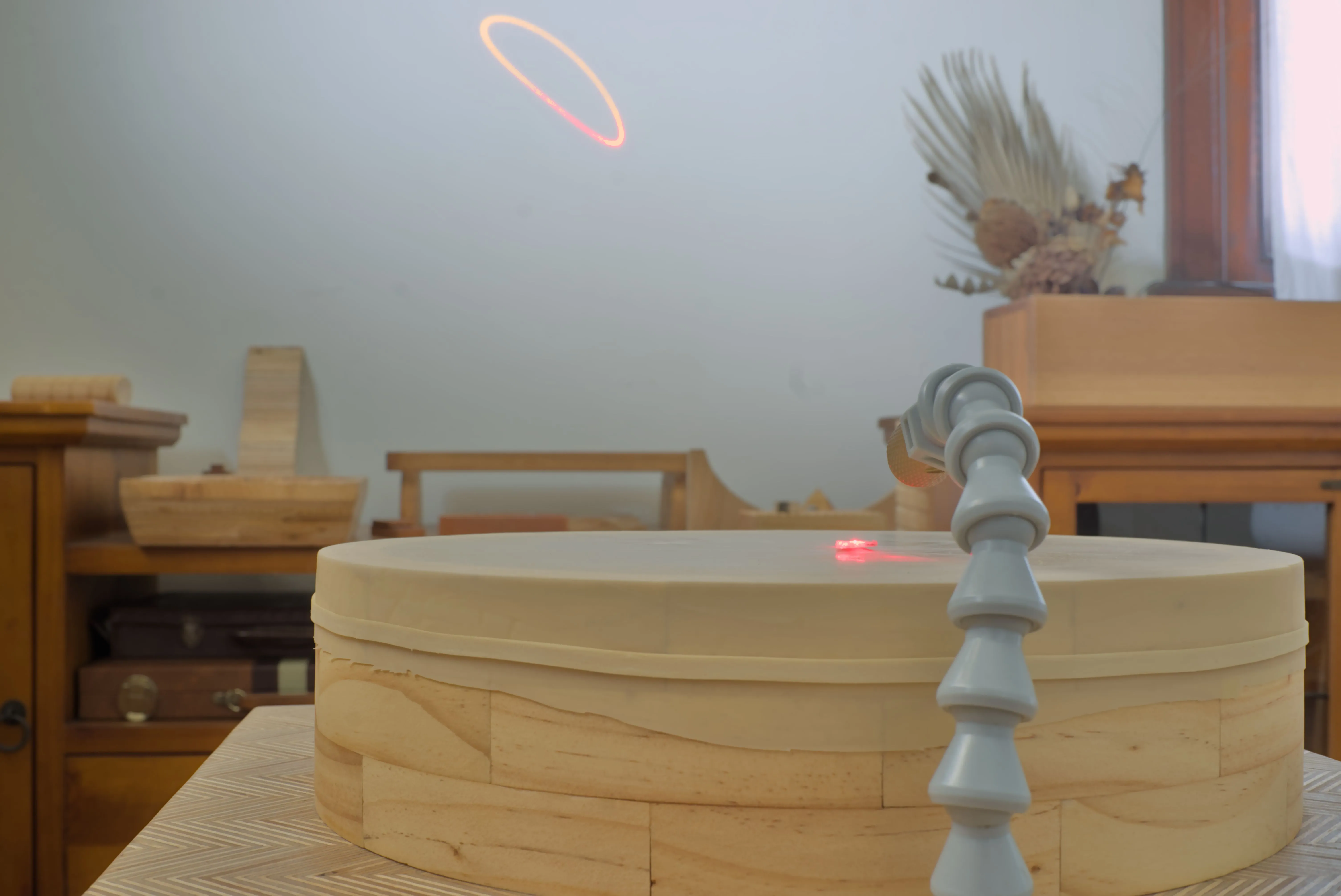 A wood cylinder and a laser pattern projected onto a wall.