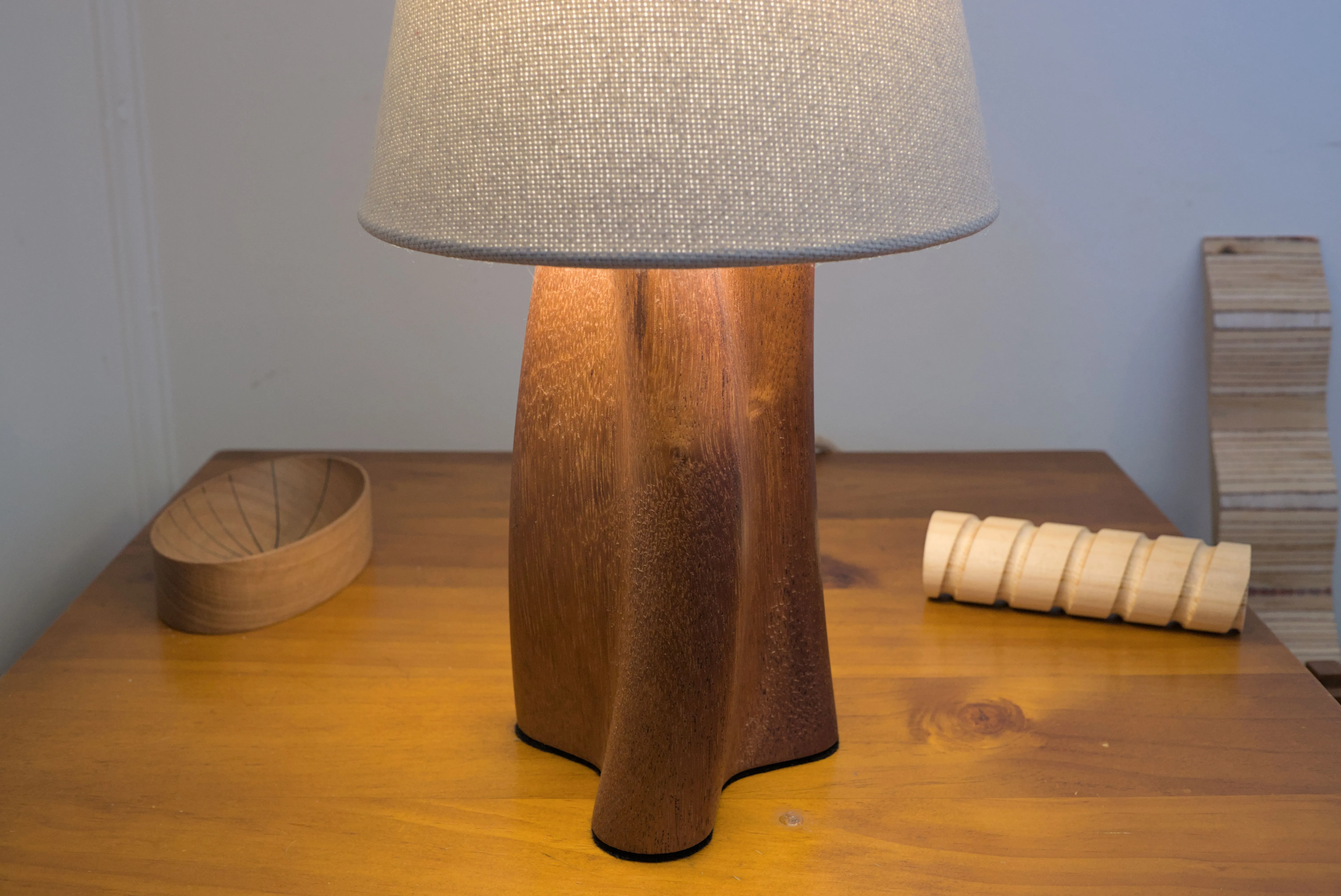 Head on view of a table lamp with a curving and twisting shape.