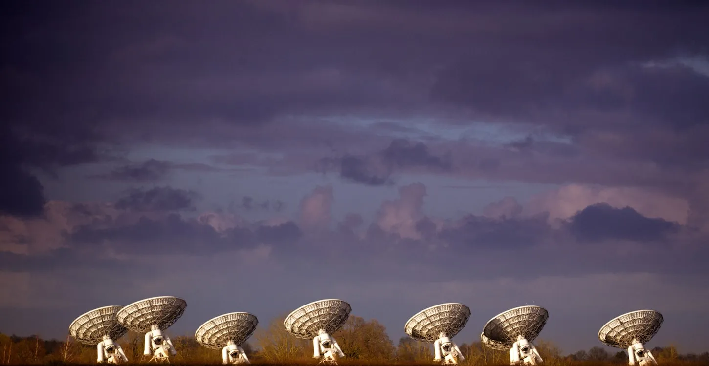 Several large radio antenna dishes pointing into the sky during daytime.